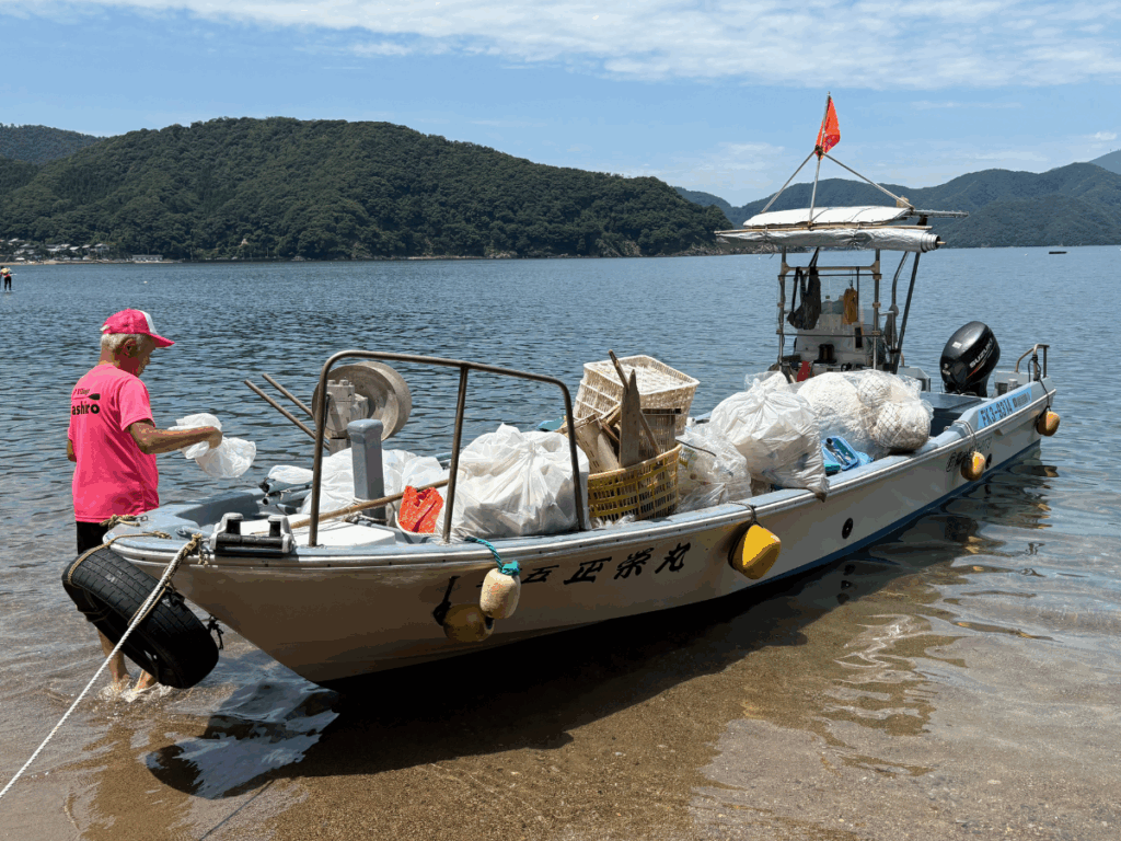回収した海洋プラスチックごみを船に乗せて戻る様子