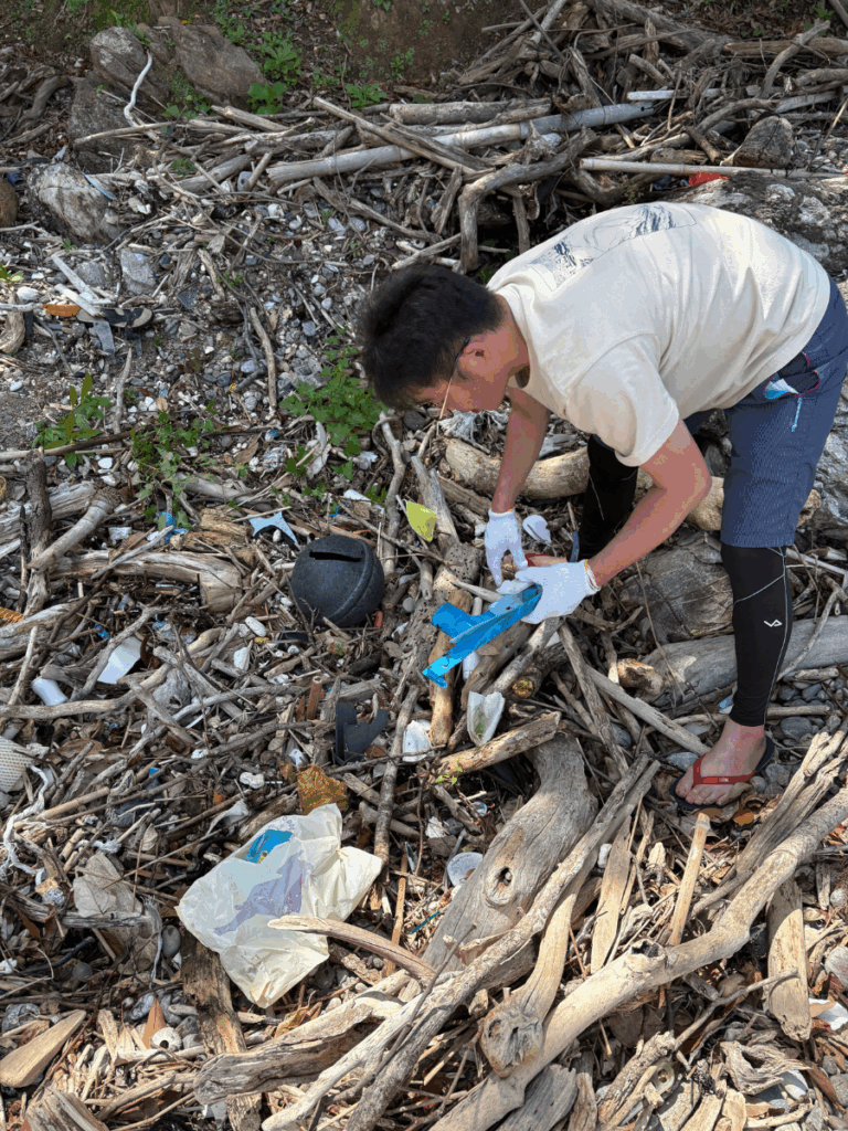 細かく砕かれた海洋プラスチックごみを手作業で拾う様子